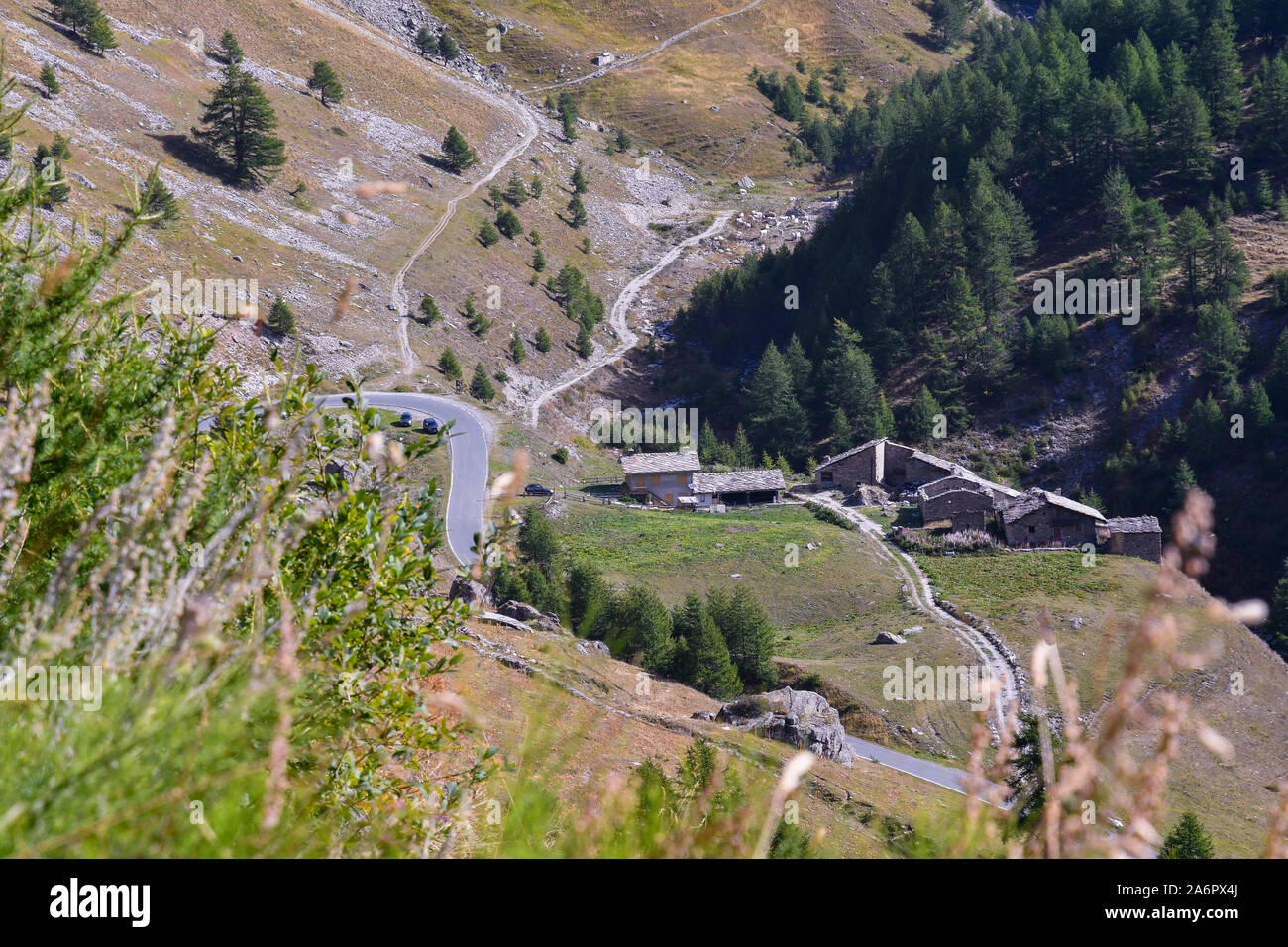 Portrait d'une vallée de montagne avec des rues sinueuses et un petit village alpin avec chalets en pierre dans un beau jour d'été, Chianale, Piémont, Italie Banque D'Images