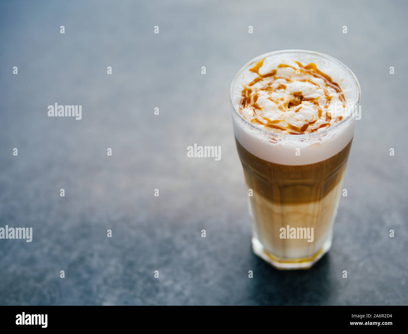 Sex latte macchiato café avec caramel foncé sur d'examen avec l'espace négatif pour la conception. La lumière naturelle. L'espace de copie pour le texte. Banque D'Images