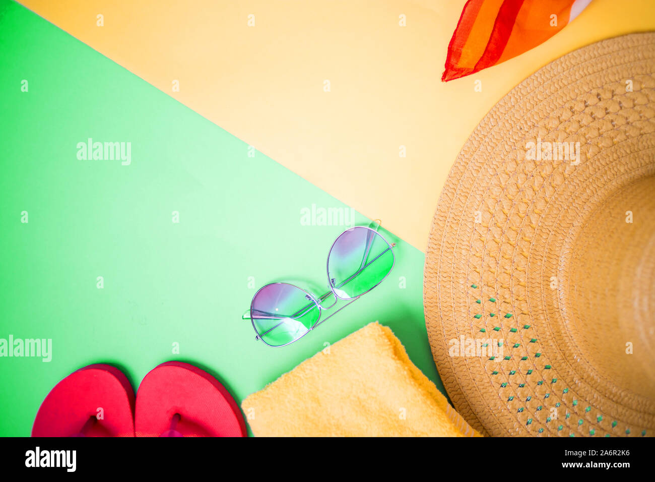 Lunettes de soleil, serviette, tongs rose vif sur fond vert et jaune clair. Vue de dessus, copiez l'espace pour le texte. Accessoires de plage, été, vacances. Banque D'Images