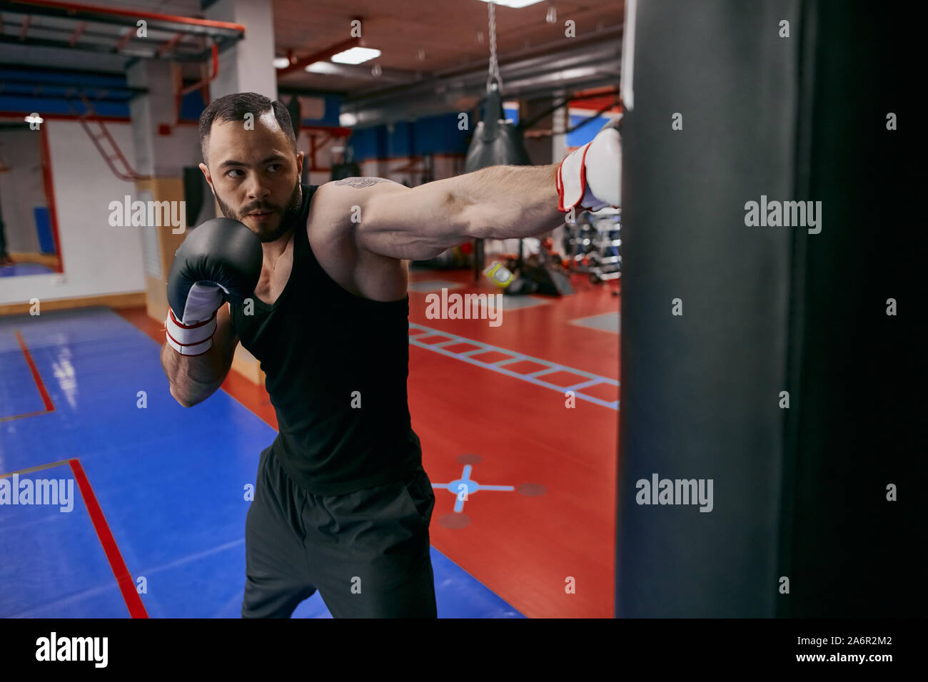 Jeune homme bien bâti qui fréquentent des cours de boxe, la photo en gros. rés.formation. santé et soins du corps, défi Banque D'Images