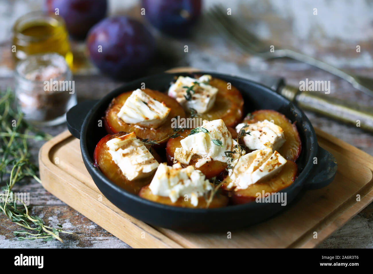 Les prunes cuites au four avec du fromage feta. L'alimentation de l'automne. Régime céto. Focus sélectif. Macro. Banque D'Images