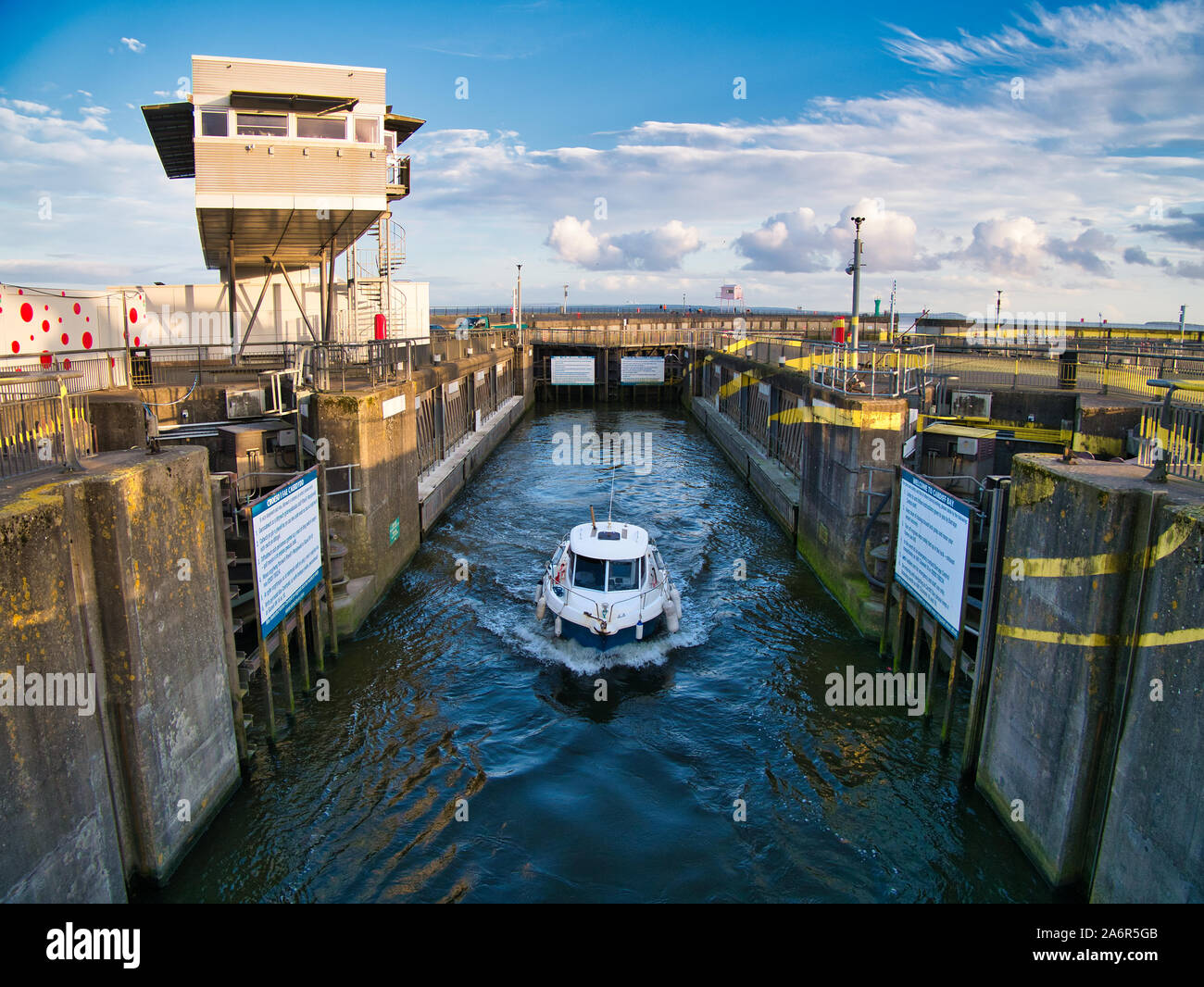Un bateau quitte l'une des trois écluses de barrage de Cardiff à Cardiff, Pays de Galles, Royaume-Uni - le barrage salle de contrôle est en haut à gauche de la photo. Banque D'Images