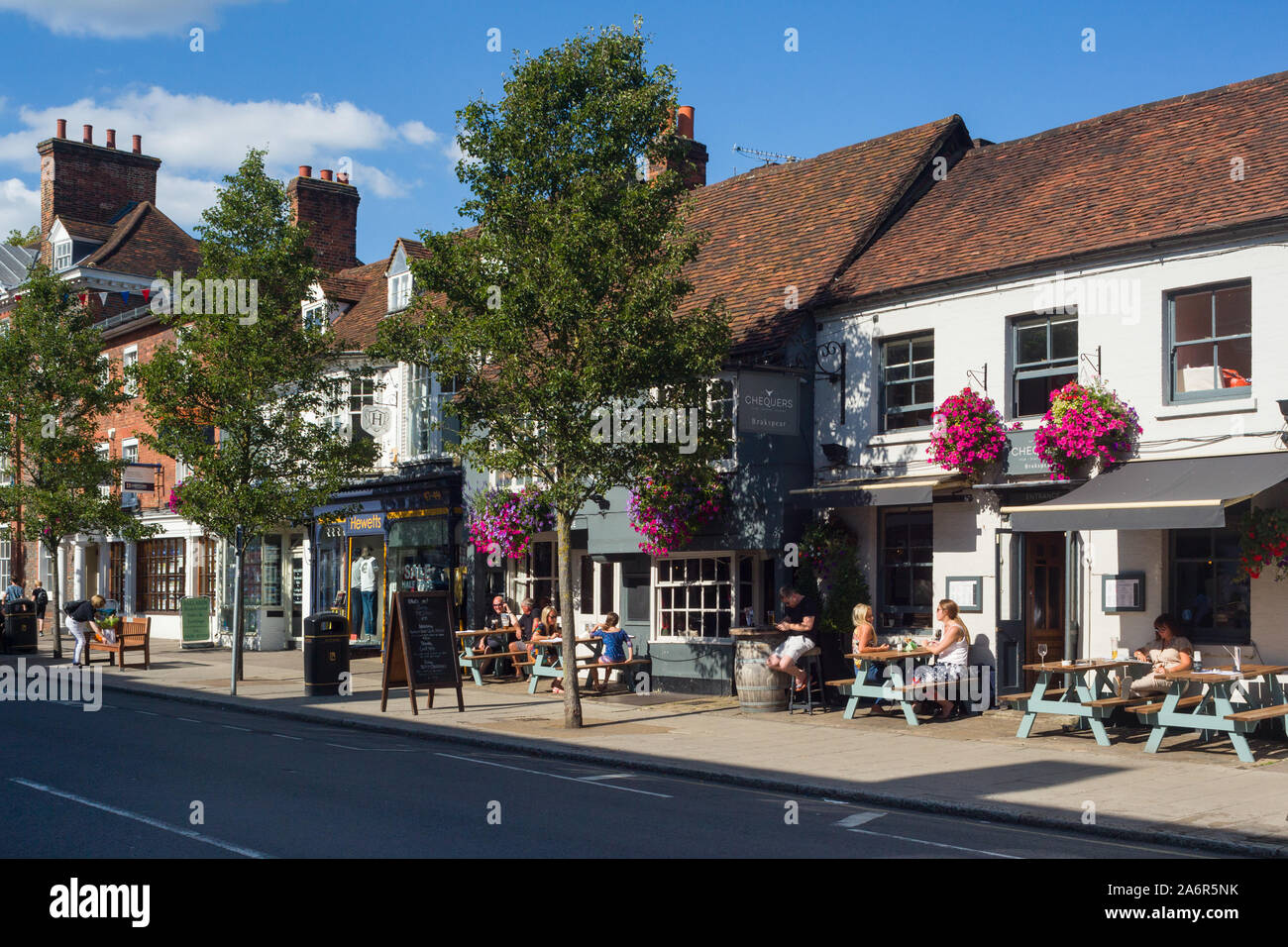 Les gens assis à l'extérieur d'un pub du soleil sur la grande rue, à Marlow, dans le Buckinghamshire avec fleurs colorées Banque D'Images