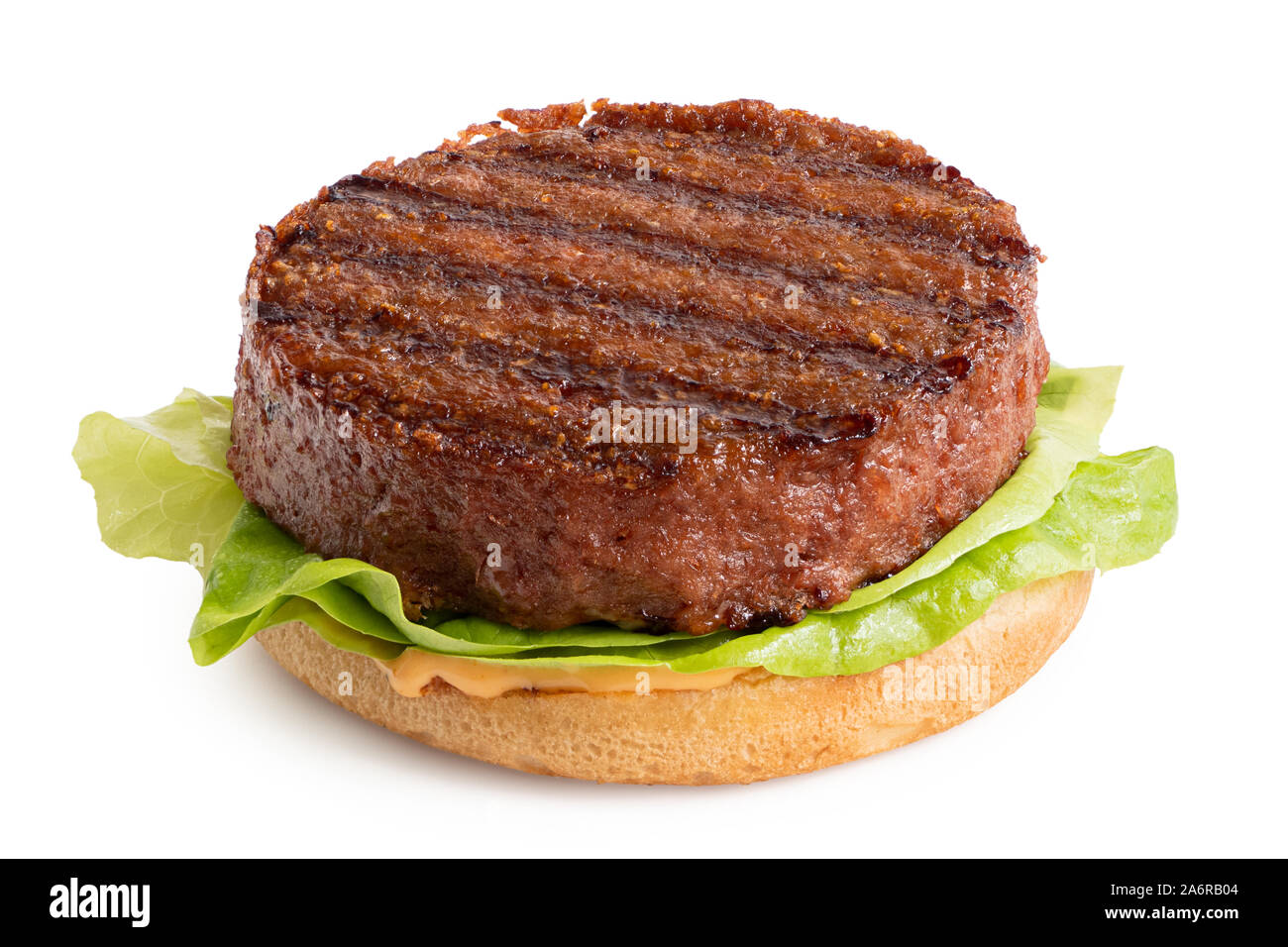 Base de plantes fraichement grillés sur patty burger bun avec laitue et de la sauce isolé sur blanc. Banque D'Images