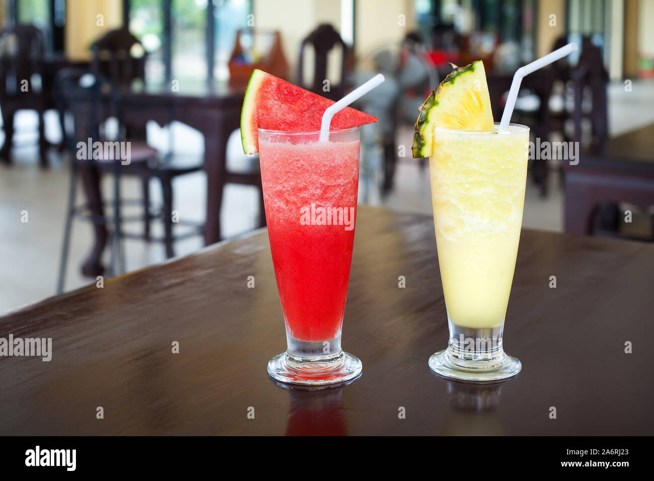 La pastèque et l'ananas fruits tranchés, gros plan secoue pièces, paille, deux fruits avec garniture dans verres transparents sur table dans un bar, boisson froide Banque D'Images