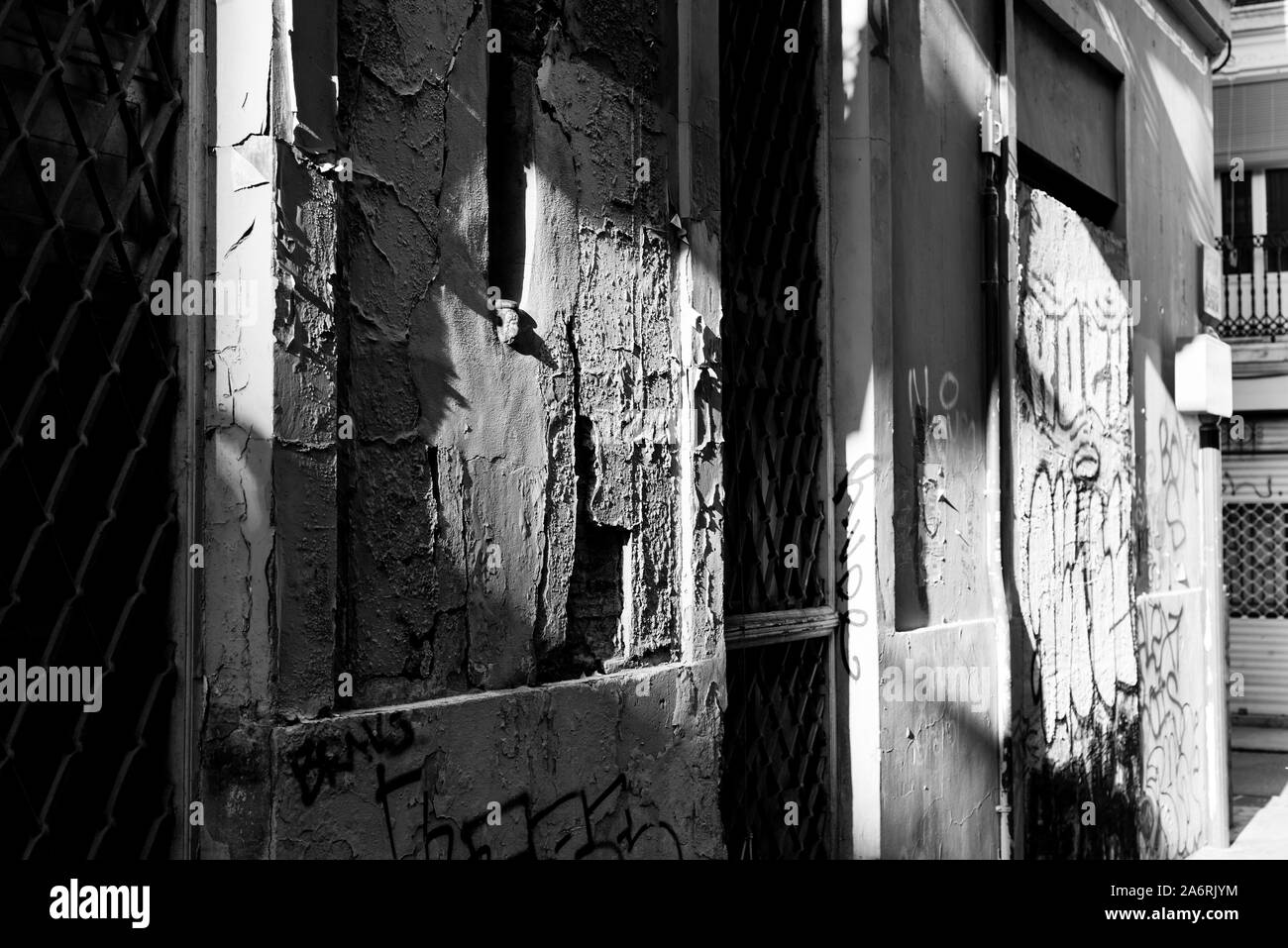 La lumière du soleil du soir jette des ombres sur un mur en ruine d'un vieux bâtiment dans la partie ancienne de la ville de Valence, en Espagne. Banque D'Images