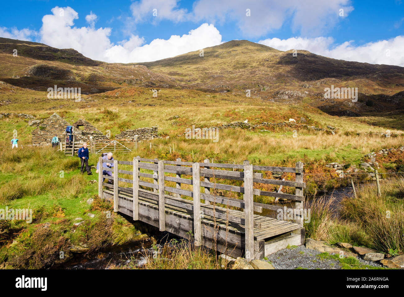 Une passerelle d'eau de montagne avec les randonneurs randonnée sur chemin sous Yr Aran dans le parc national de Snowdonia. , Beddgelert Gwynedd, au nord du Pays de Galles, Royaume-Uni, Angleterre Banque D'Images