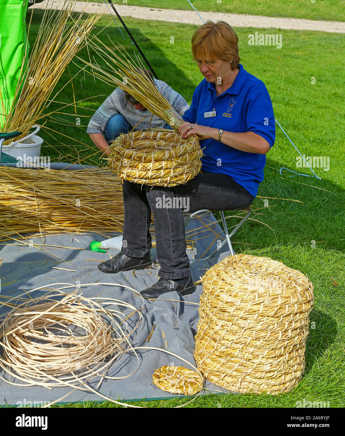 Une femme du Derbyshire - faire une ruche paille apiculteurs à Chatsworth Jeu ou Country Fair, Chatsworth House, Derbyshire, Angleterre, RU Banque D'Images