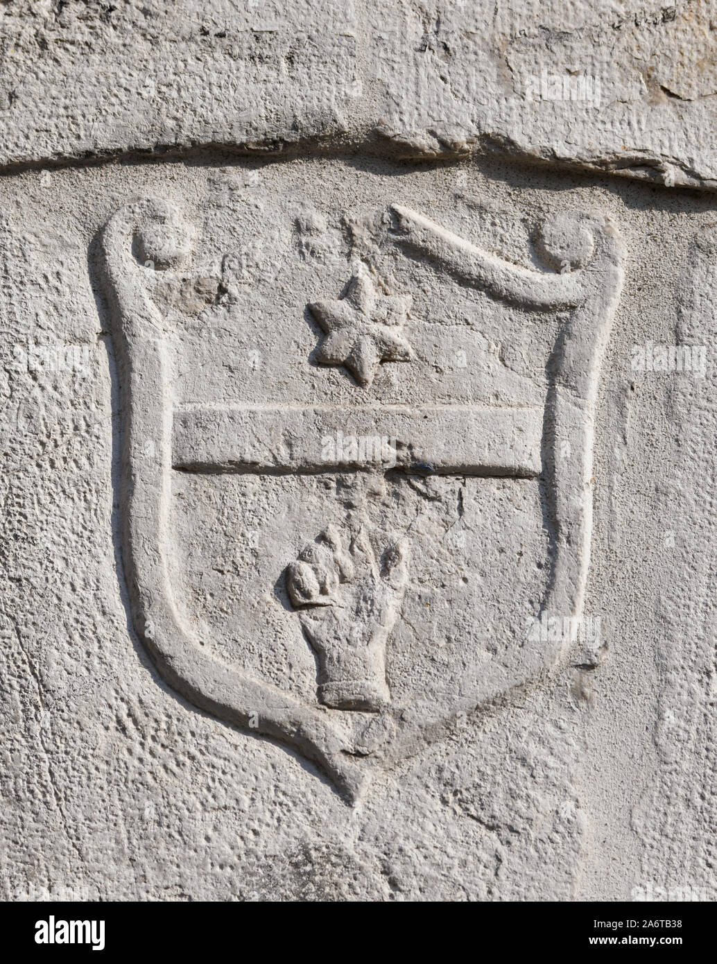 Vieux et endommagés signe héraldique d'une main à une étoile points relief sur un mur de Venise Banque D'Images