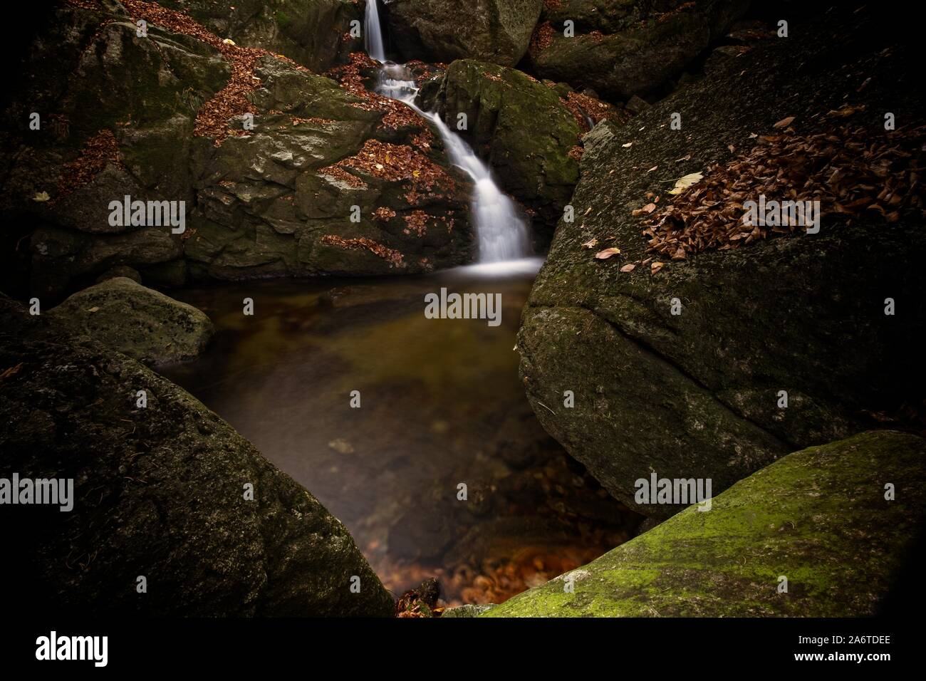 L'automne d'une exposition longue de creek et Noir (Big) Stolpich cascades dans les montagnes Jizera. L'eau tombe dans un profond canyon de la forêt pleine de pierres de granit Banque D'Images