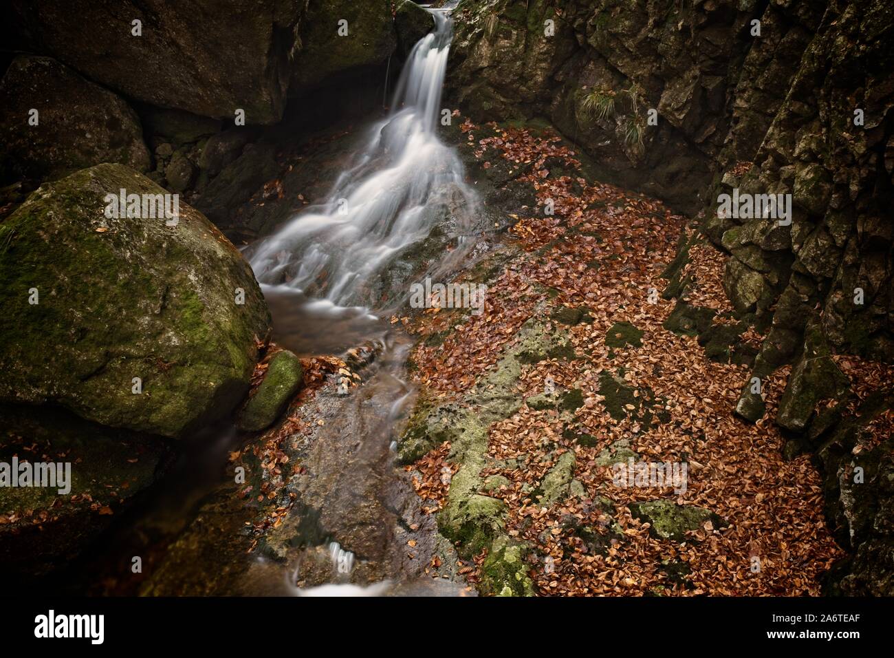 L'automne d'une exposition longue de creek et Noir (Big) Stolpich cascades dans les montagnes Jizera. L'eau tombe dans un profond canyon de la forêt pleine de pierres de granit Banque D'Images