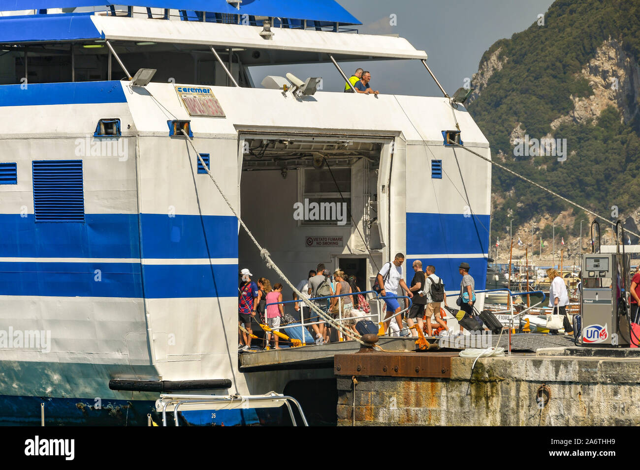 Île de Capri, ITALIE - AOÛT 2019 : Les gens d'embarquer dans un ferry sur la rampe du véhicule dans le port sur l'île de Capri. Banque D'Images