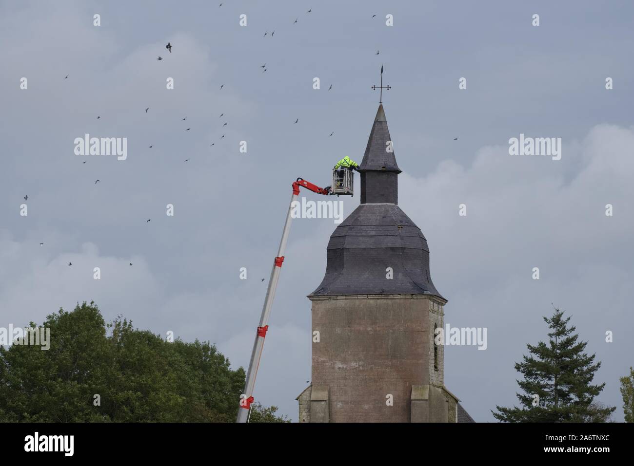 Réparations du toit en ardoise d'une église du XVIIIe siècle à l'aide d'une plate-forme de travail aérienne ou d'un pont d'araignée Banque D'Images