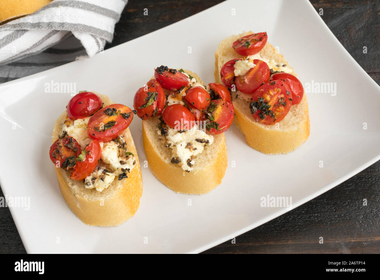 Bruschetta au four garni de tomates raisins, Feta et herbes fraîches : tranches de pain grillé au four garni de fromage feta, tomates raisins, et des herbes fraîches Banque D'Images