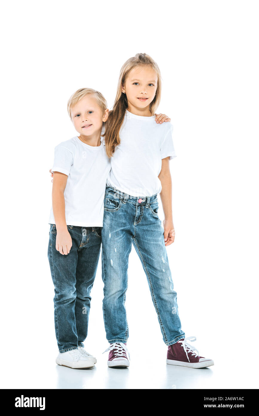 Heureux soeur et frère en jeans standing on white Banque D'Images