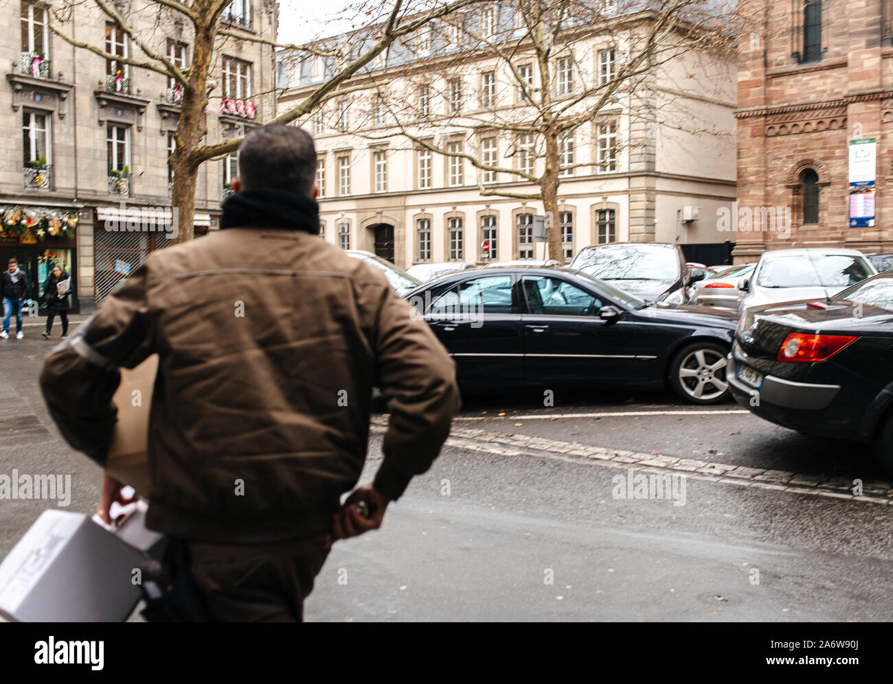 Strasbourg, France - Dec 27, 2017 : side view of UPS United parcel Service employé marche sur rue française pour livrer colis Banque D'Images