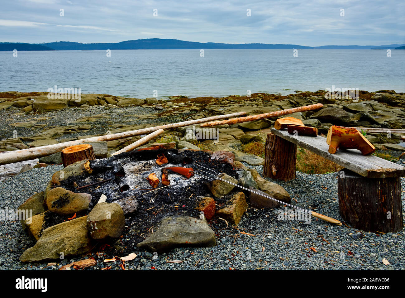 Un cercle de pierres apportées au cercle inscrit d'un feu de camp sur une plage sur la côte rocheuse de l'île de Vancouver en Colombie-Britannique au Canada. Banque D'Images
