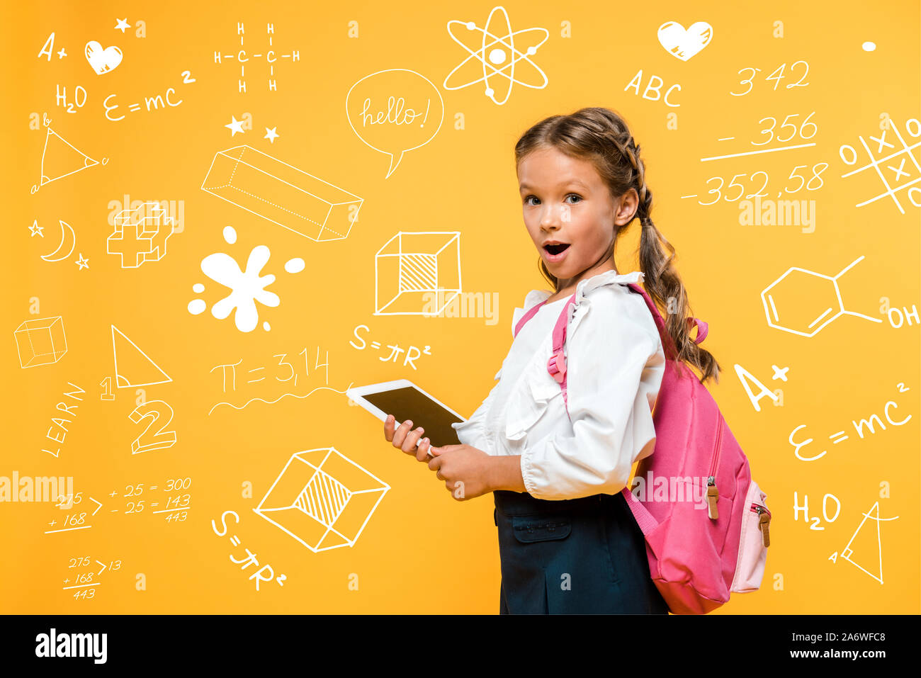 Surpris schoolkid holding digital tablet avec écran vide près de formules mathématiques sur orange Banque D'Images