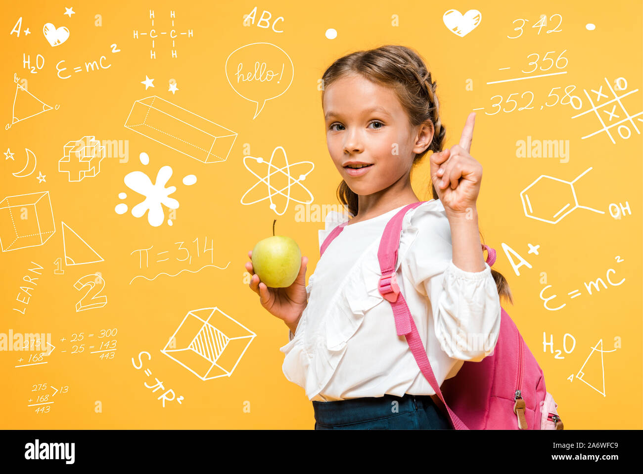 Adorable schoolkid holding apple et en pointant avec le doigt près de formules mathématiques sur orange Banque D'Images