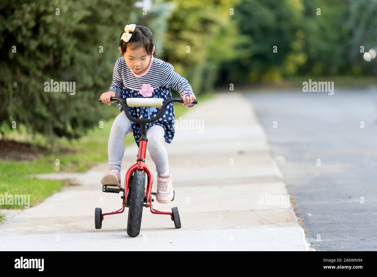 Cute little girl learning monter à vélo sans casque Banque D'Images