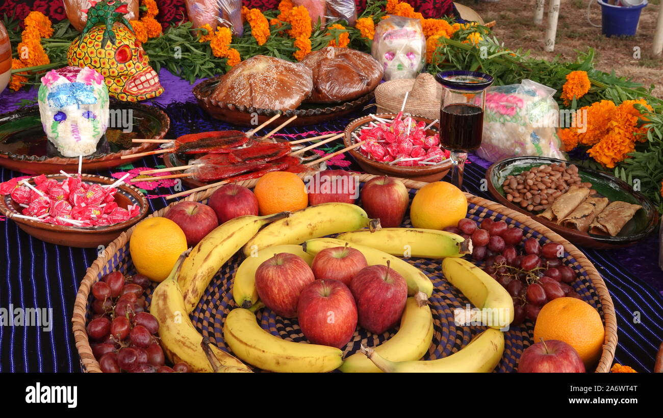 Le Jour des Morts (autel ofrenda) avec de la nourriture, des bonbons, du sucre des crânes et des œillets. Banque D'Images