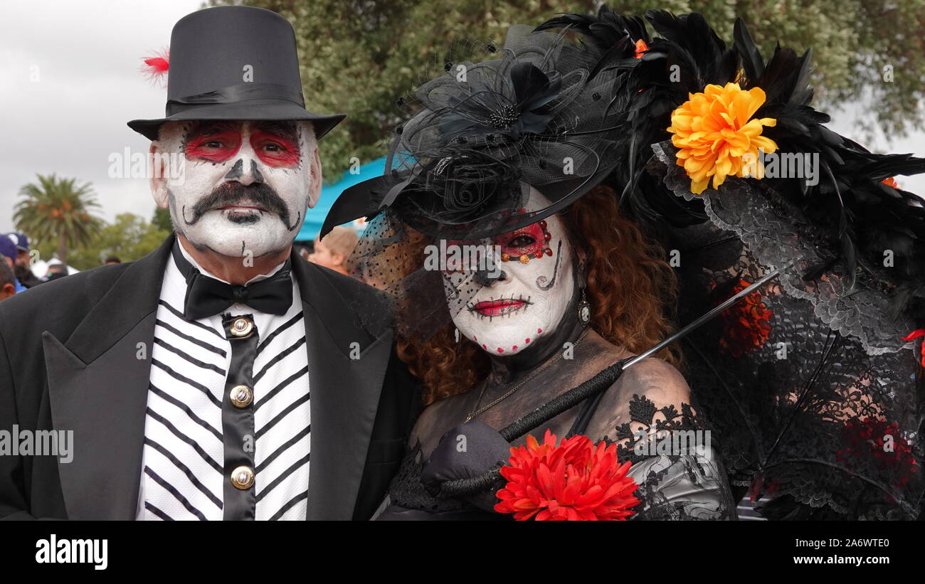 Vieux couple avec crâne en sucre et maquillage fantaisie vêtements vintage à Dia de los Muertos événement à Mission San Luis Rey. Banque D'Images