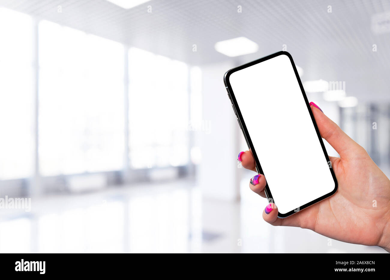 Maquette du smartphone en main Femme avec centre d'arrière-plan. Maquette du smartphone sans cadre moderne avec écran blanc. L'espace vide pour le texte. Co Banque D'Images Maquette du smartphone en main Femme avec centre d'arrière-plan. Maquette du smartphone sans cadre moderne avec écran blanc. L'espace vide pour le texte. Co Banque D'Images