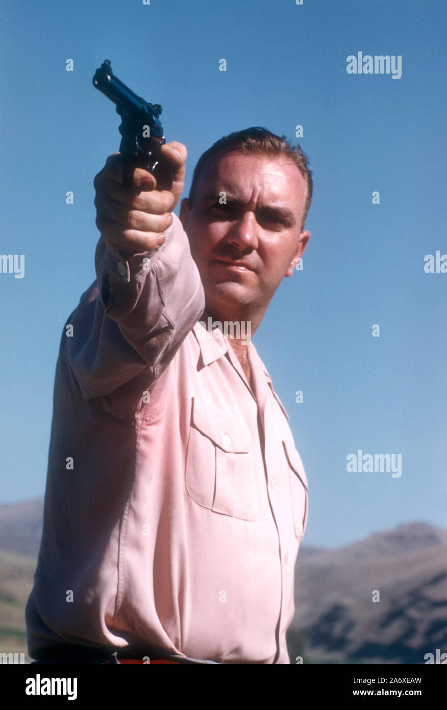 LEWISTON, Idaho - Juillet 1951 : vue générale en tant qu'homme, montre son arme comme il prend une pause de la chasse de la marmotte dans le désert vers juillet 1951 à Lewiston, Maine. (Photo de Hy Peskin) (Définition du nombre : X1484) Banque D'Images