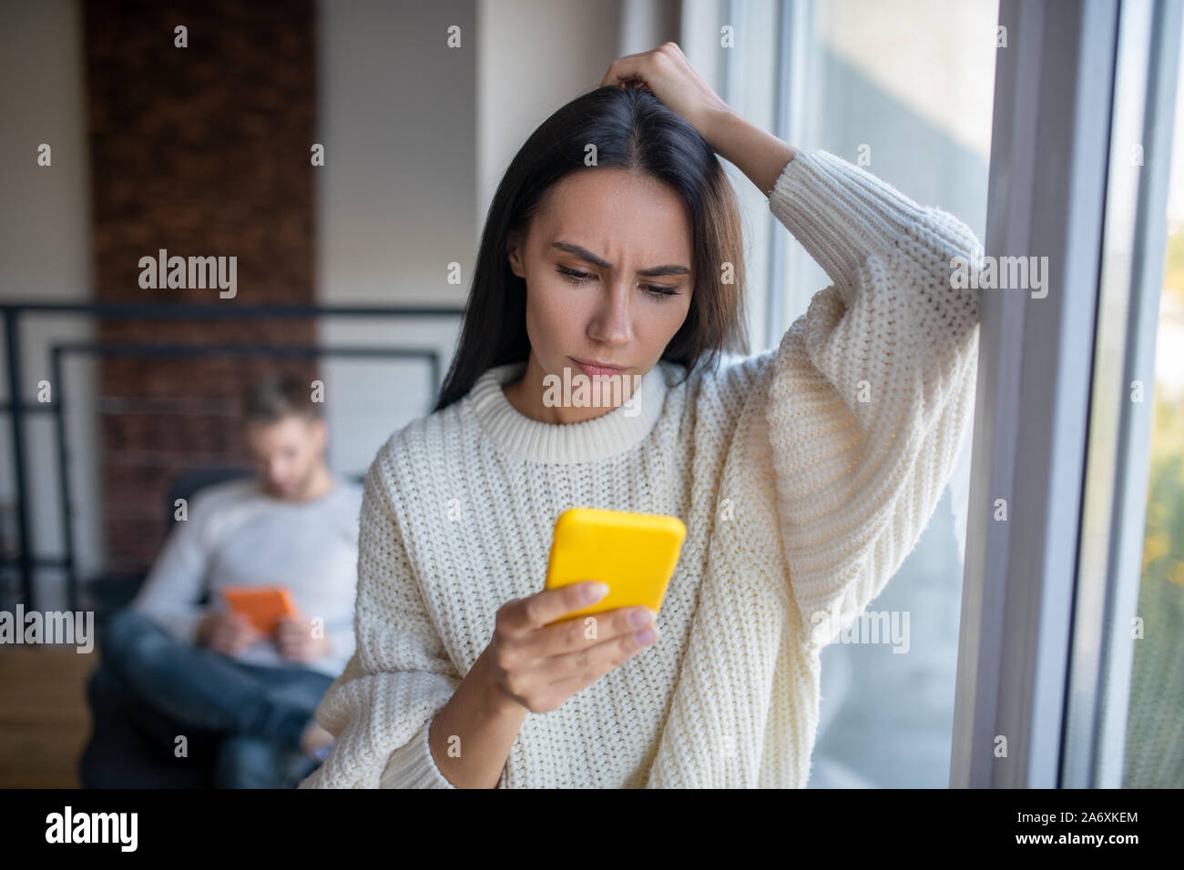 Femme portant un sentiment de confusion pull beige lit un message Banque D'Images