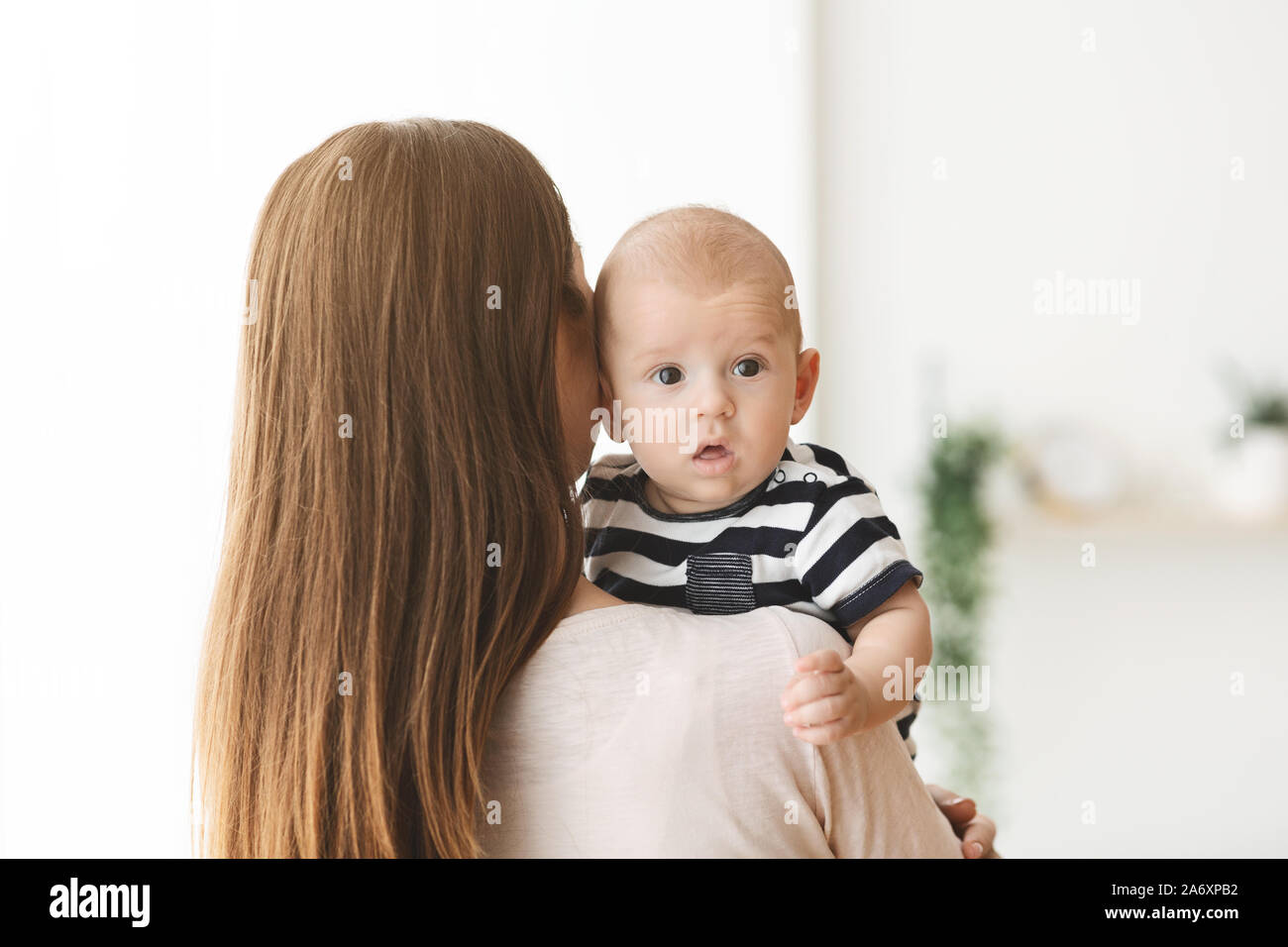 Mignon petit bébé couché sur l'épaule de la mère Banque D'Images