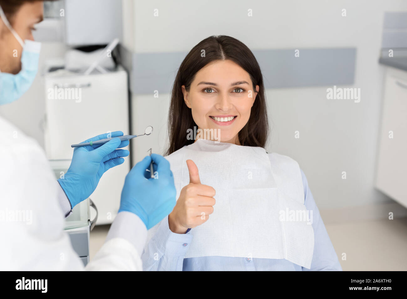 Convaincu jeune femme dentiste président showing thumb up Banque D'Images