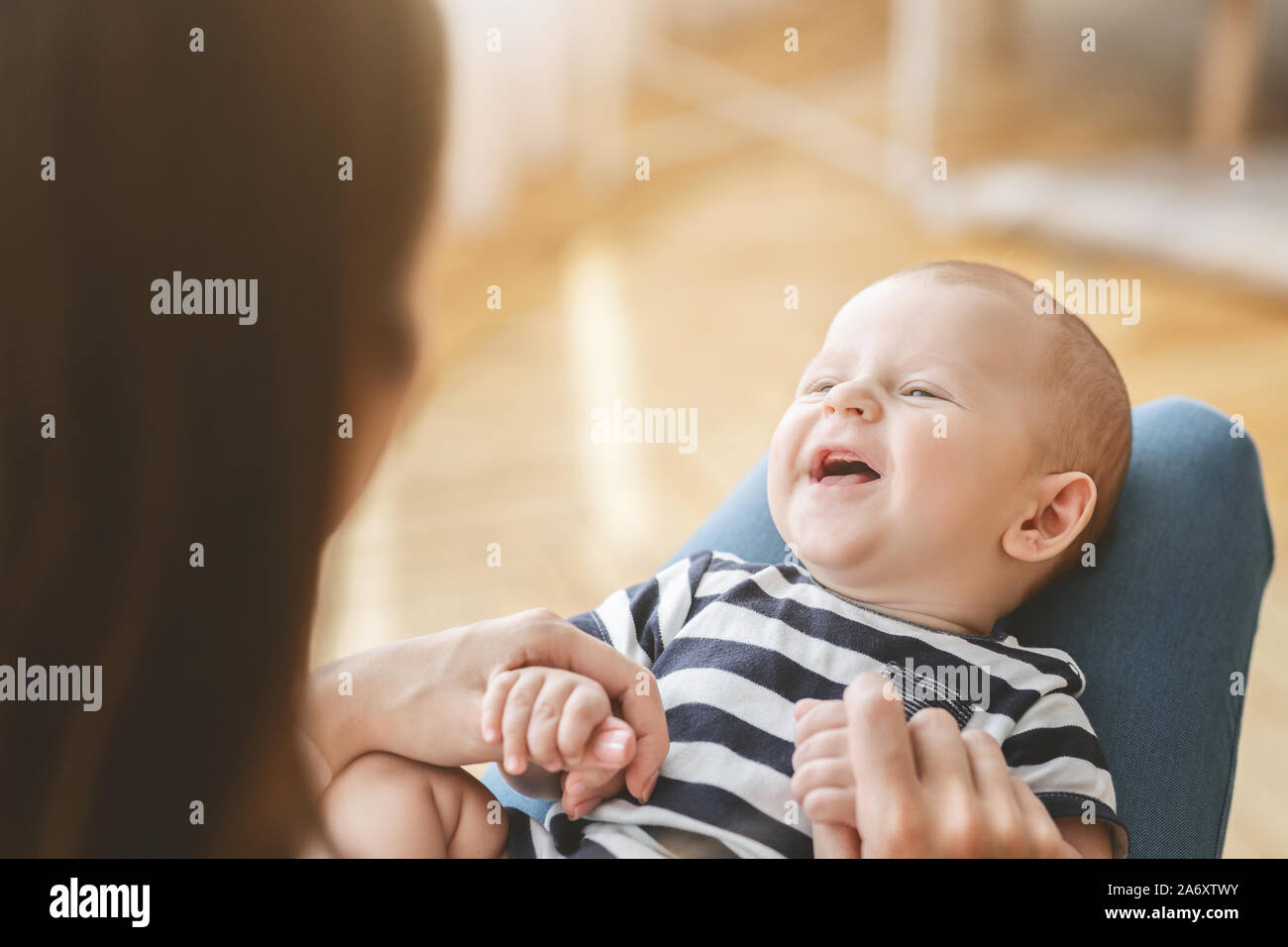 Drole De Bebe Nouveau Ne Riant Couchee Sur Les Genoux De Mere Photo Stock Alamy