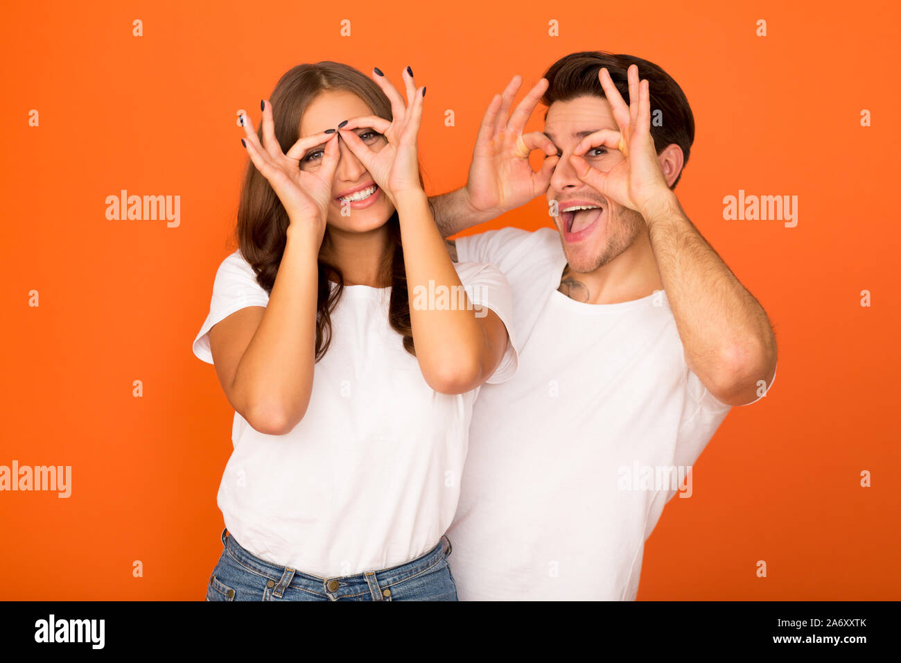 Crazy couple making funny griffes de lunettes, près de yeux Banque D'Images