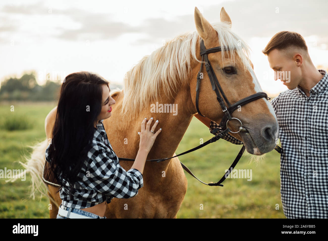 Heureux couple aimant passer du temps avec les chevaux de ranch Banque D'Images