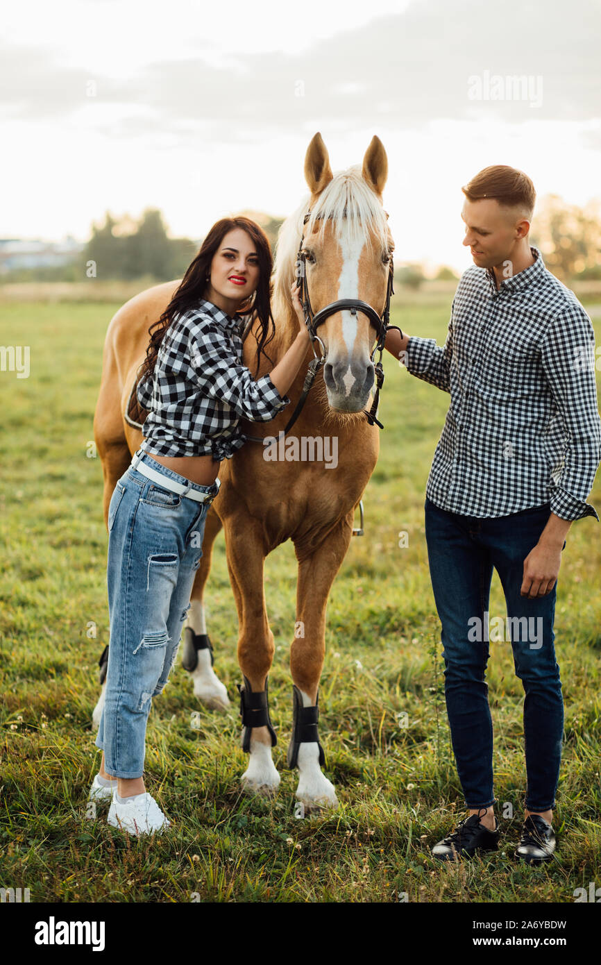 Heureux couple aimant passer du temps avec les chevaux de ranch Banque D'Images