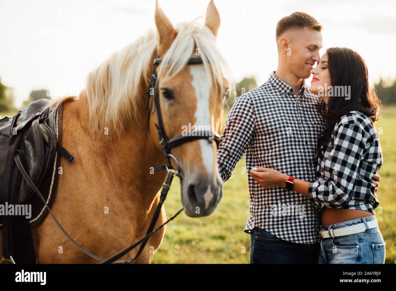 Heureux couple aimant passer du temps avec les chevaux de ranch Banque D'Images