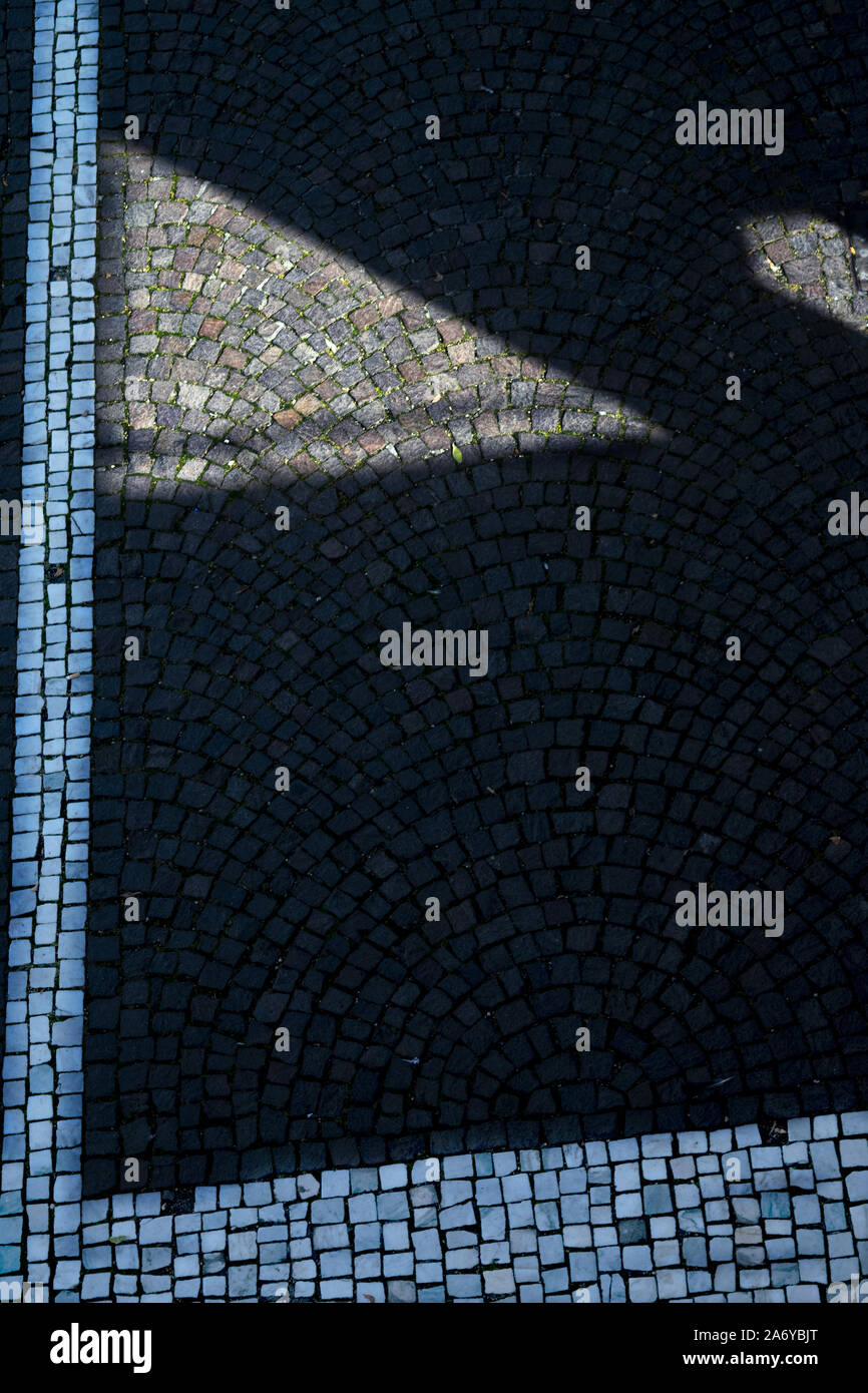 Des géométries et des lignes sur un pavé d'une rue Banque D'Images