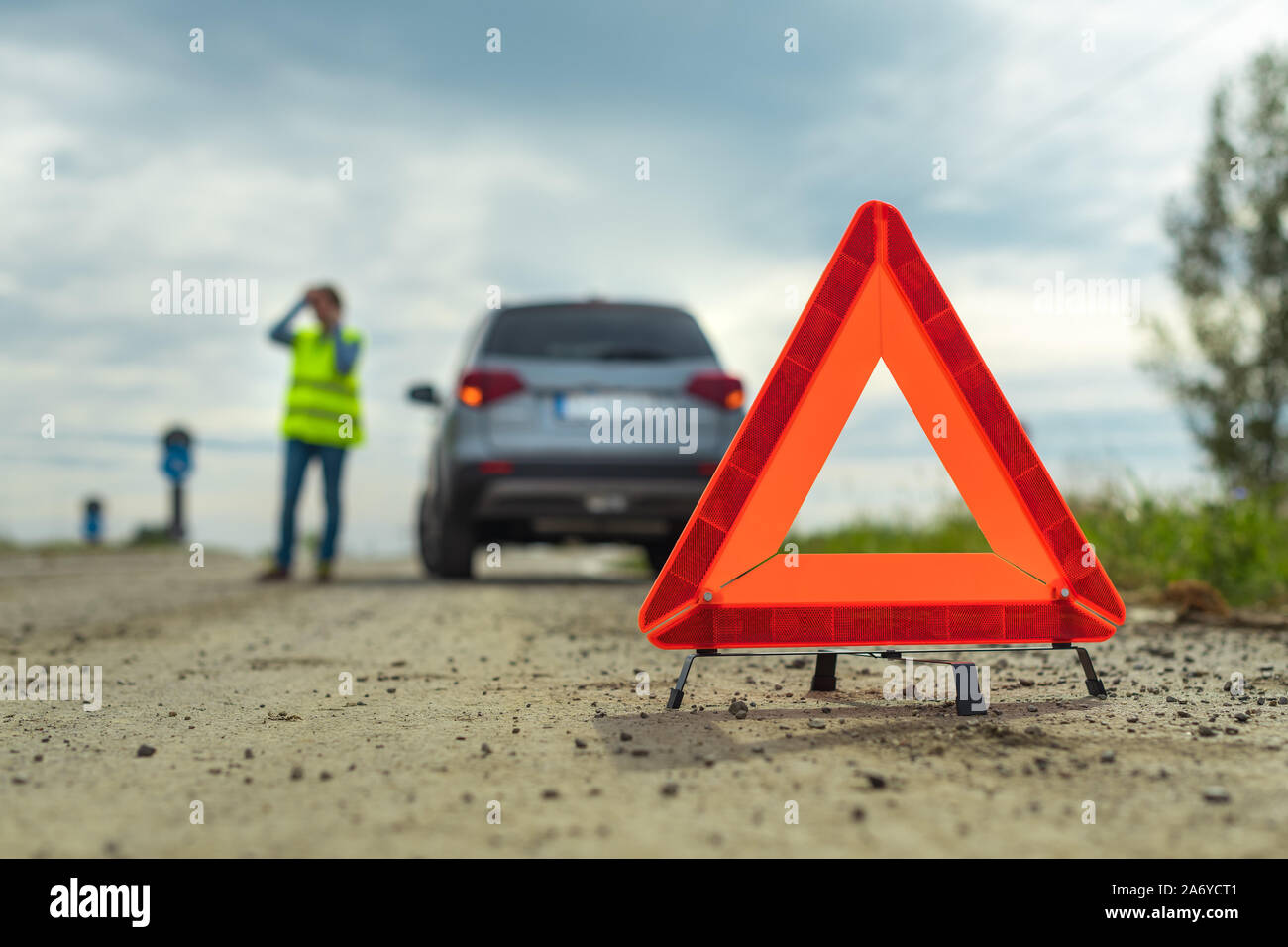 Panne du véhicule et le triangle sur la route, la femme à l'aide de téléphone pour demander de l'aide et l'assistance routière Banque D'Images