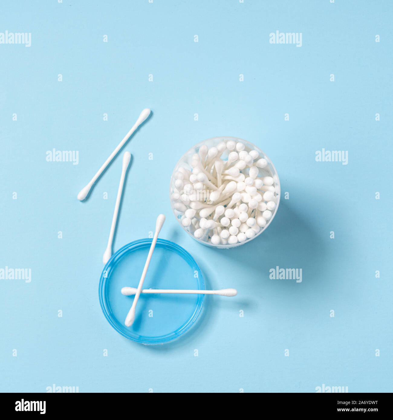 Quelques tampons de coton dans un récipient sur une surface bleue Banque D'Images