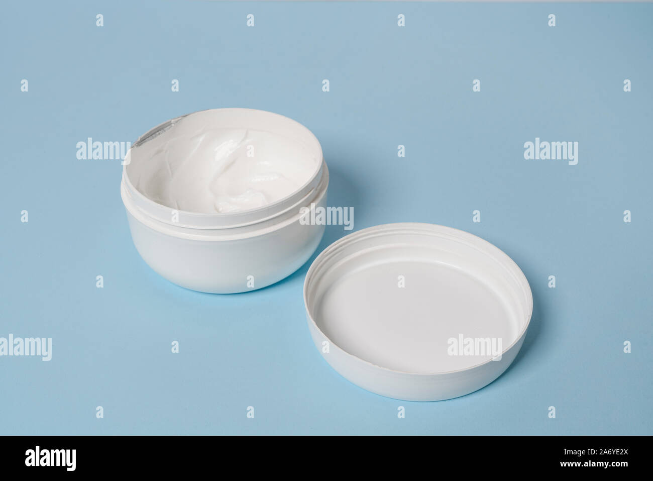 Un pot de crème hydratante crème sur une surface bleue Banque D'Images