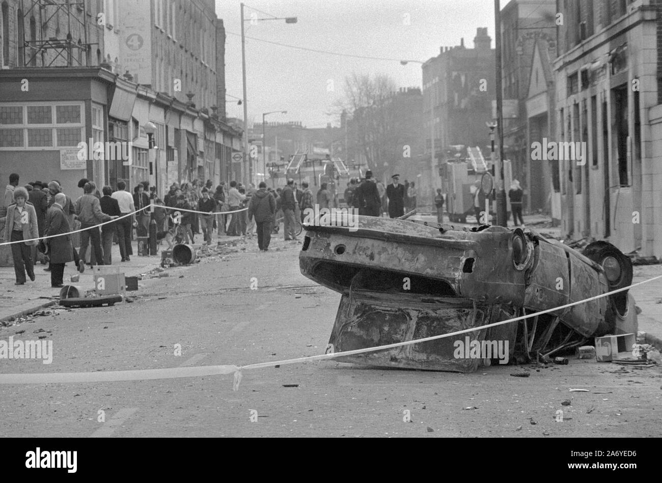 Un véhicule renversé Burnett-out se trouve dans les débris éparpillés Railton Road, Brixton, Londres, théâtre d'émeutes de la nuit dernière. Banque D'Images Un véhicule renversé Burnett-out se trouve dans les débris éparpillés Railton Road, Brixton, Londres, théâtre d'émeutes de la nuit dernière. Banque D'Images