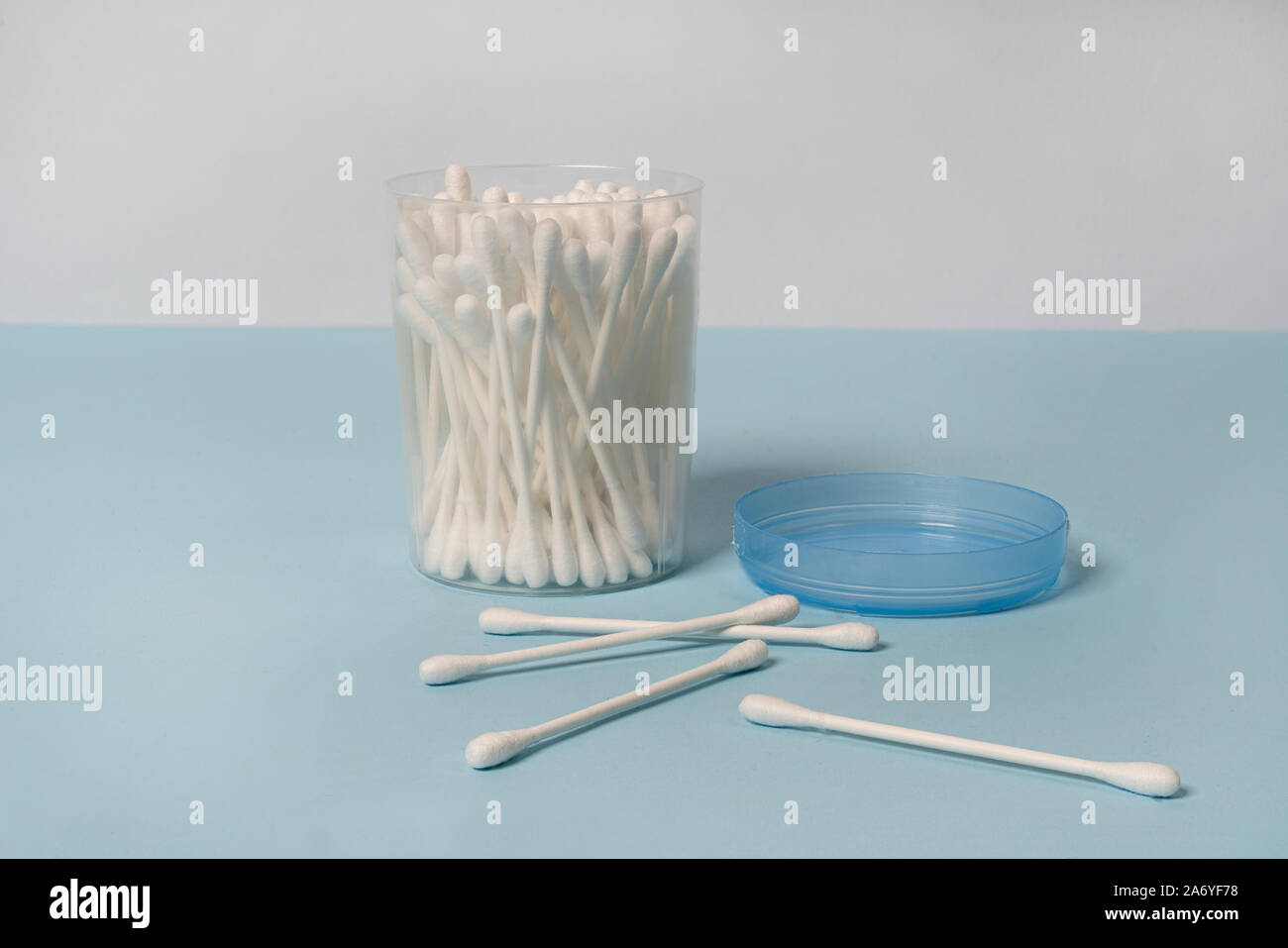 Quelques tampons de coton dans un récipient sur une surface bleue Banque D'Images