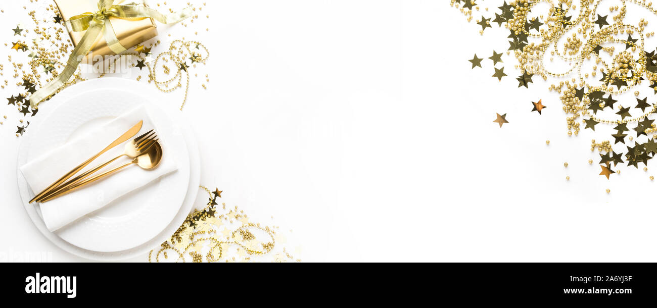 Réglage de la table de Noël avec de la vaisselle d'or, l'argenterie et les décorations de fête sur fond blanc. Vue d'en haut. Le dîner de Noël. Banque D'Images