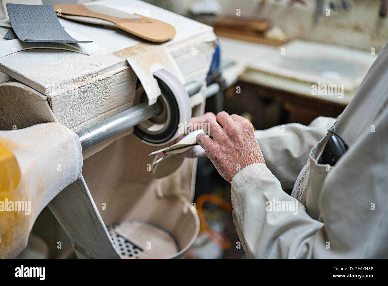 Artisan professionnel de semelles orthopédiques, polissage et ponçage contrôler dans son atelier la modélisation de l'acquisition avec un verre fin lathe Banque D'Images
