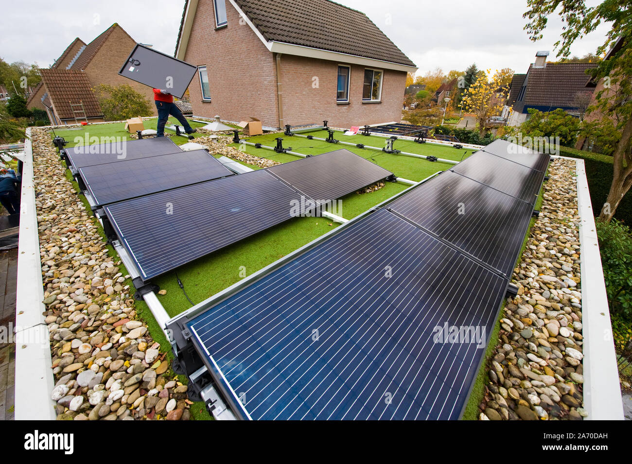 Un travailleur est l'installation de panneaux solaires sur un toit plat aux Pays-Bas Banque D'Images