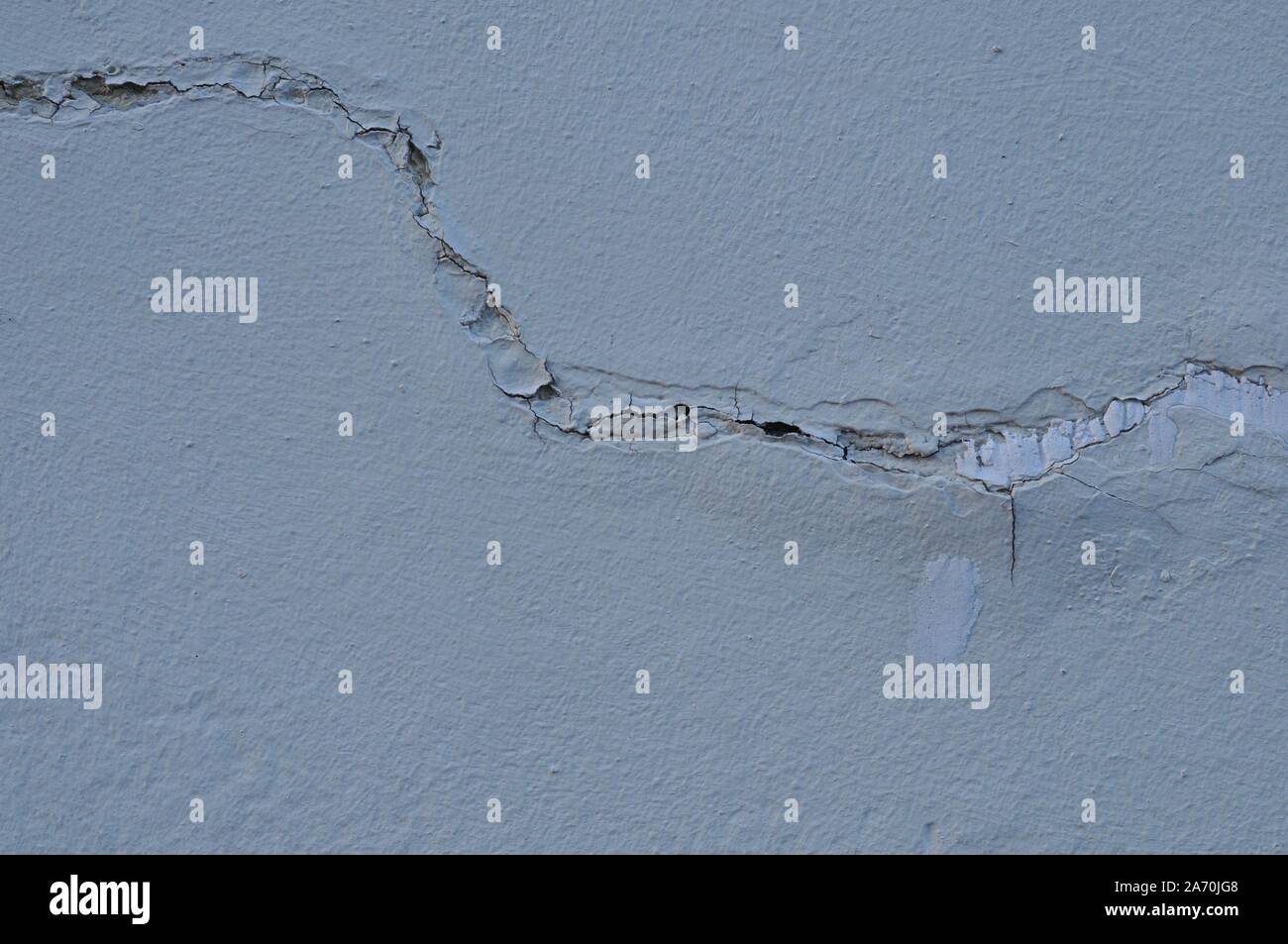 Broken fissurée Plâtre patiné détruit la peinture sur mur blanc extérieur Banque D'Images