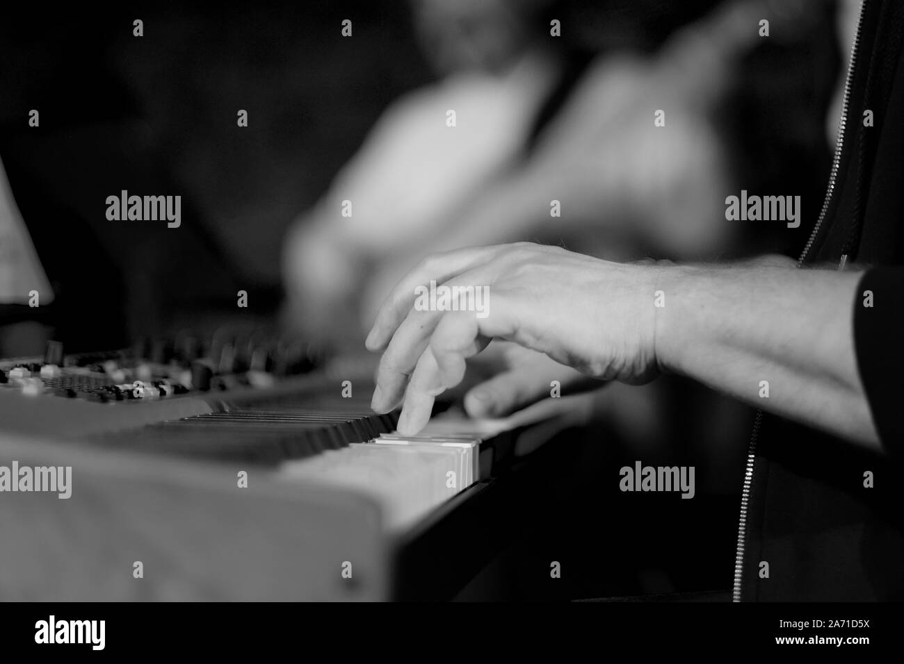 Un musicien sur un piano électrique joue la musique en direct à un concert d'un orchestre Banque D'Images