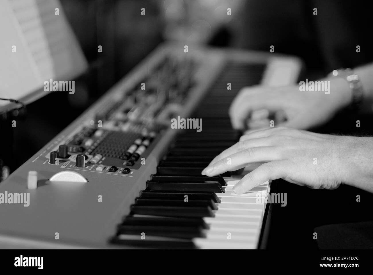 Un musicien sur un piano électrique joue la musique en direct à un concert d'un orchestre Banque D'Images