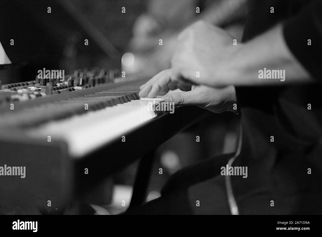 Un musicien sur un piano électrique joue la musique en direct à un concert d'un orchestre Banque D'Images