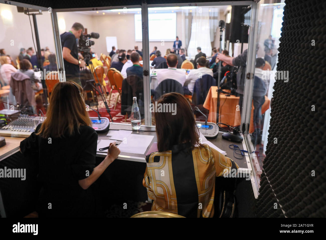 Deux femmes les traducteurs s'asseoir dans une cabine de traduction au cours d'une conférence internationale Banque D'Images